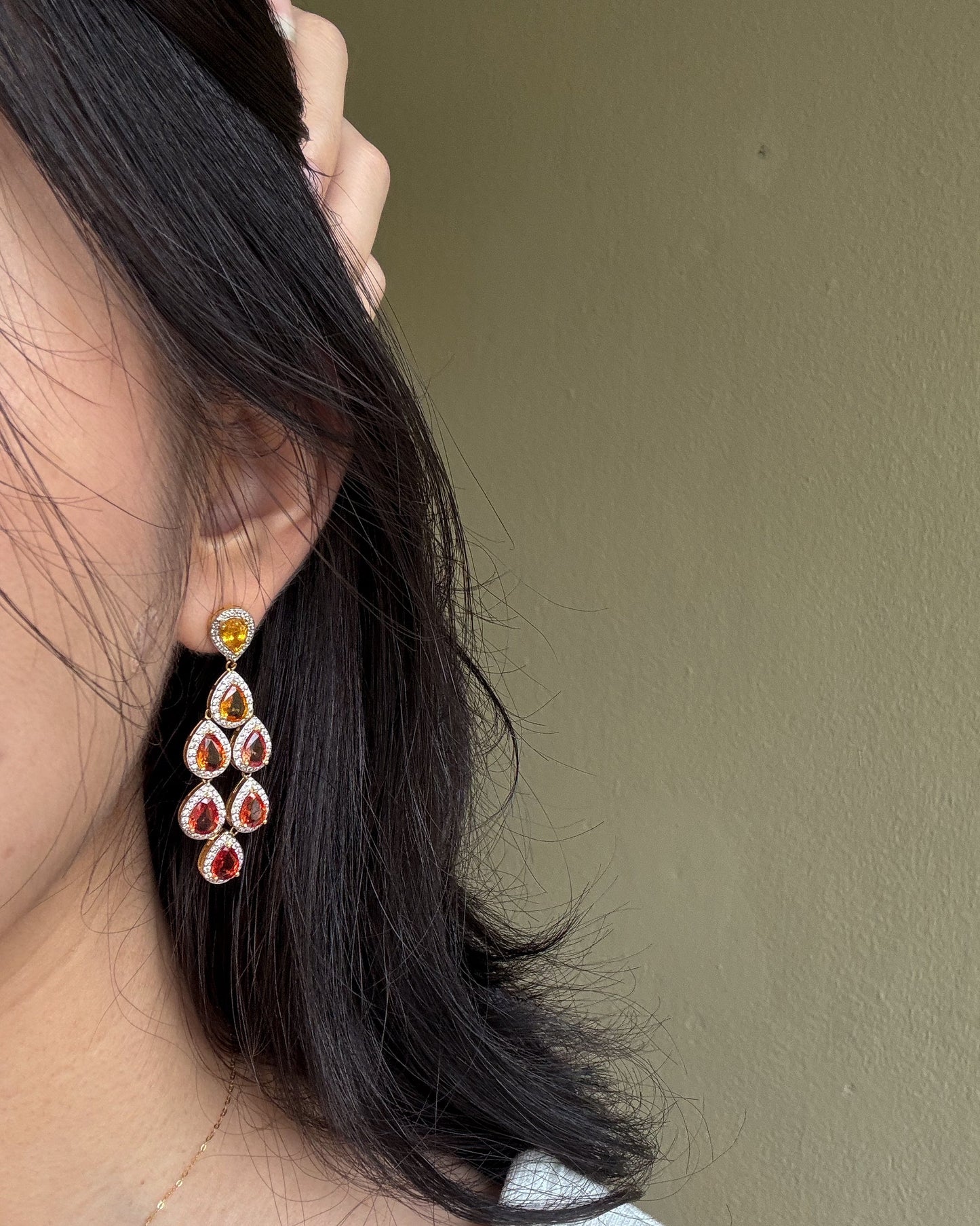 Close-up of a person wearing sapphire drop earrings