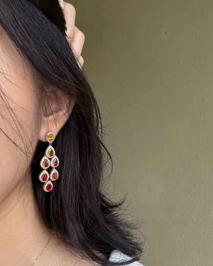 Close-up of a person wearing sapphire drop earrings
